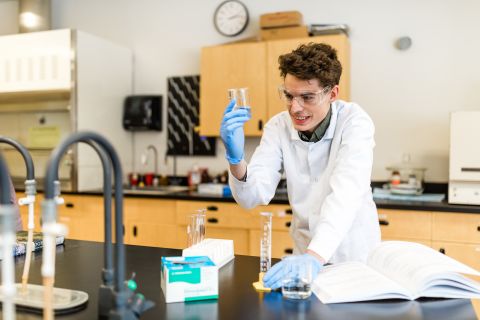 Chemistry student works with beakers in the lab