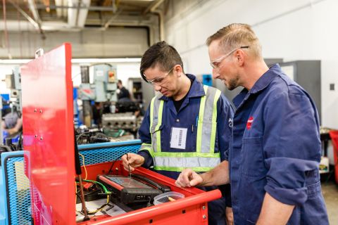 Automotive student uses diagnostic instruments with the help of an instructor