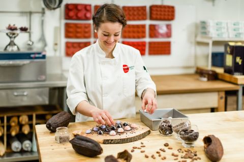 Pastry Arts student and apprentice makes chocolate confections in the bake shop