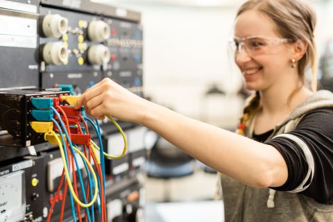 An industrial electrician apprentice works on connections in the lab.