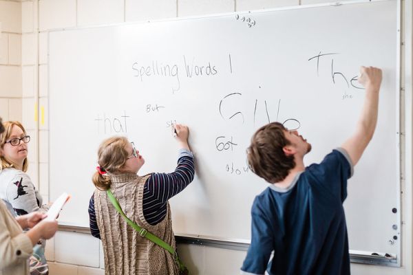 Accessible Education Certificate students writing words on a whiteboard in their classroom
