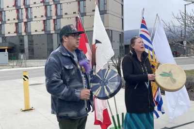 two people drumming in front of new Kelowna campus housing building