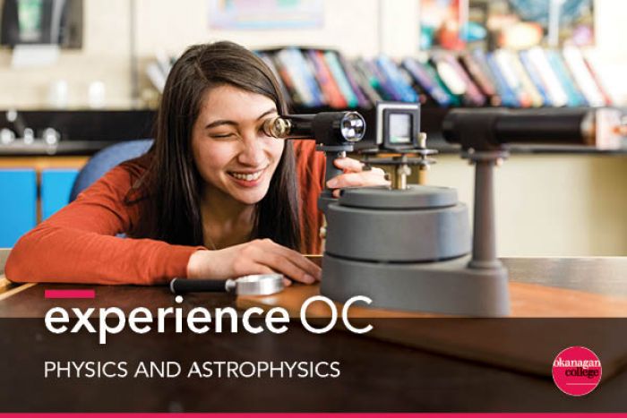 Student looks into a telescope while leaning over a desk