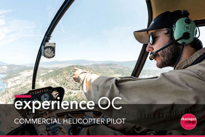 Male Student piloting helicopter pointing out window to Okanagan Valley below