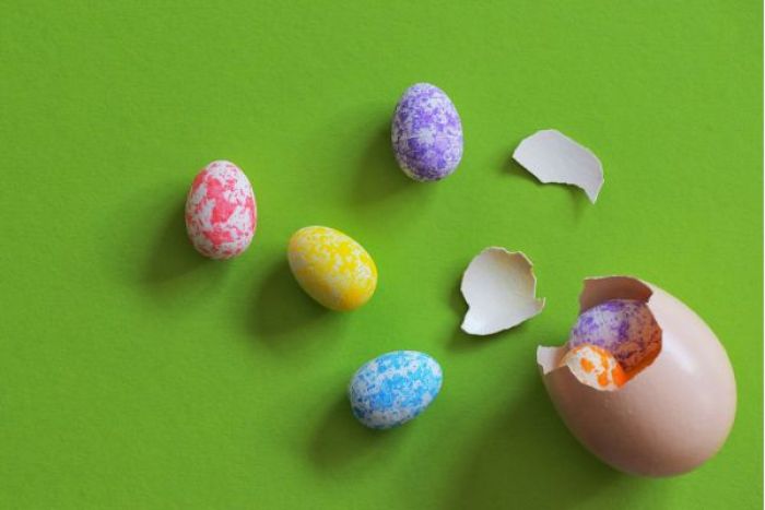 Colorful eggs laying on a green background.