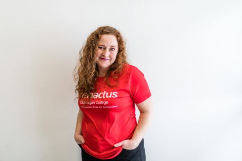 A female student wearing a red Enactus OC t shirt.