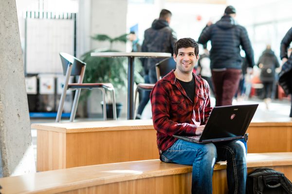 Computer Information Systems student studies on his break in a campus lounge area