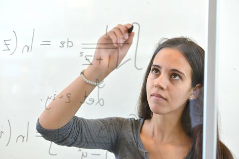 Mathematics student calculates a problem on a whiteboard
