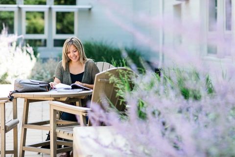 student studying outside near lavender flowers
