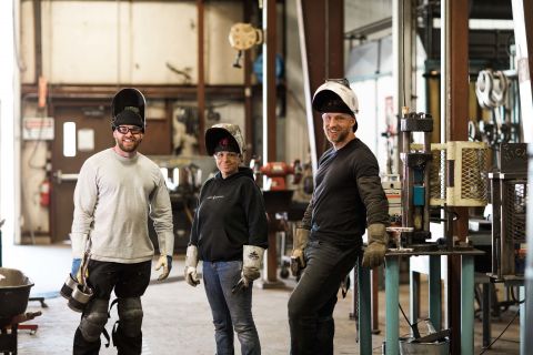 Welding students take a break in class to lift their face shields and connect