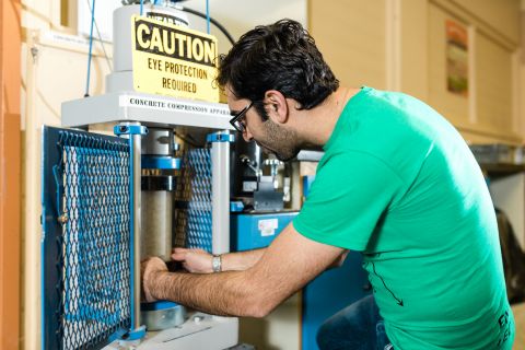 Civil Engineering Bridge student works on a concrete sample in the lab