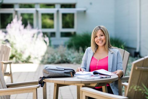 Sophie Wilson sits at a picnic table at the Penticton campus