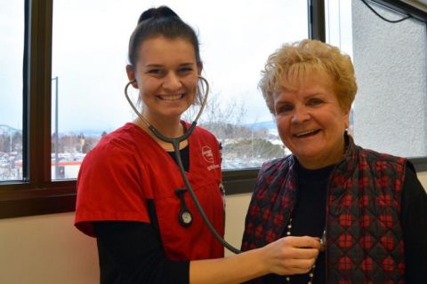 An RN students uses her stethoscope on Maxine DeHart