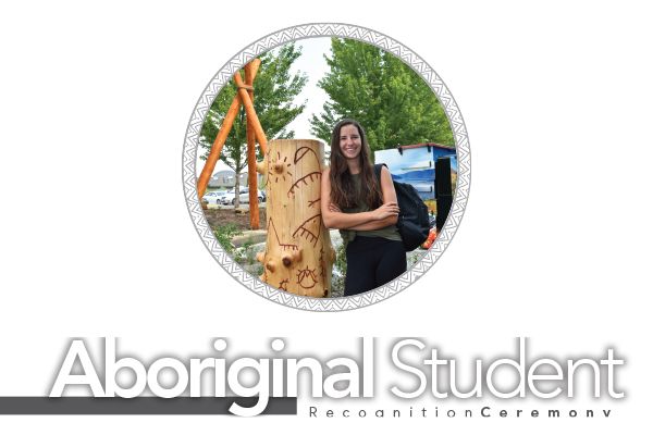Student standing beside a story pole in the Na’ʔk’ʷulamən Garden on the Kelowna campus