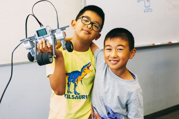 two boys building a robot at camp OC