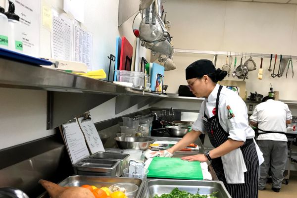 Culinary student preparing produce in the lab kitchen