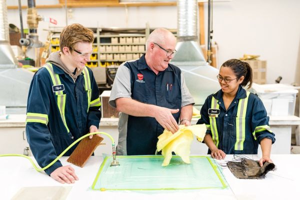 Aerospace students working in a shop with an instructor