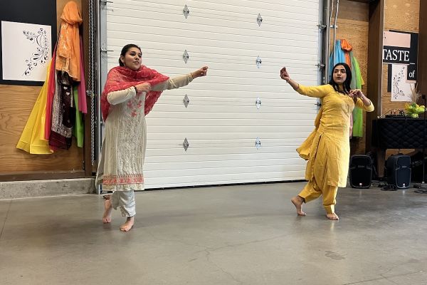 Two Indian students perform a traditional dance in sync during the Taste of India event.