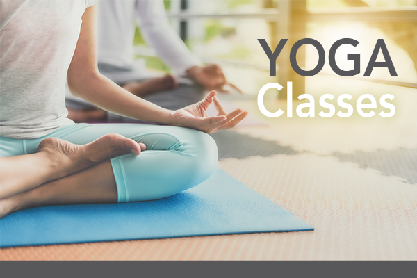 Person sitting in yoga position on yoga mat; Text: Yoga Classes