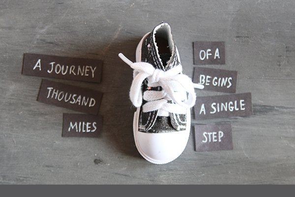 Sneaker; text: A journey of a thousand miles begins with a single step