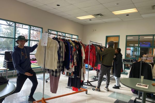 Students pose in front of a rack of clothes available for sale as part of Salmon Arm's Thrift for Charity event