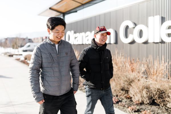 two students walking in front of the Okanagan College Trades building
