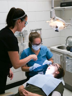 dental students examining teeth of client