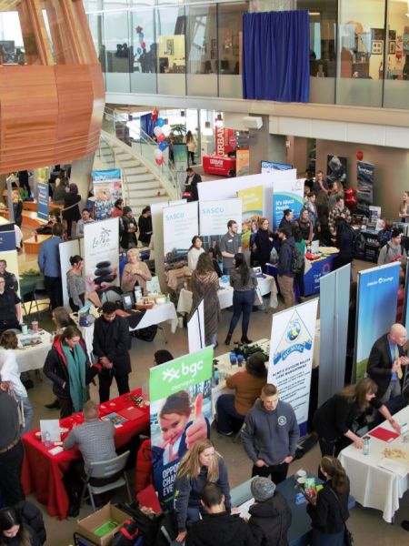 aerial view of booths set up in the Atrium with people interacting and mingling at Okanagan College's Annual Careers Expo and Employment Fair