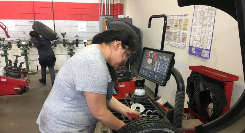 women using tire change over equipment in automotive shop
